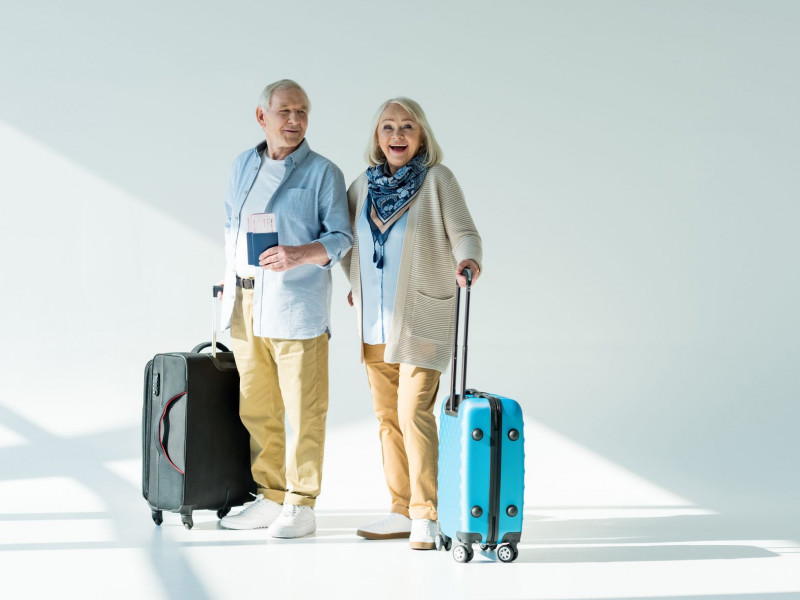 Two seniors with luggage headed to travel together