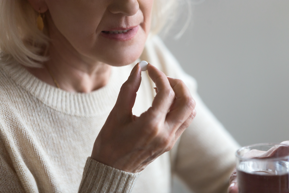 A senior woman taking a Vitamin D supplement 