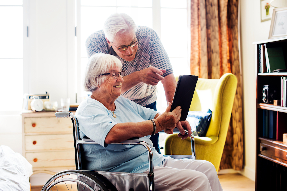 A couple at the memory care community in Oceanside video chatting on a tablet in their room