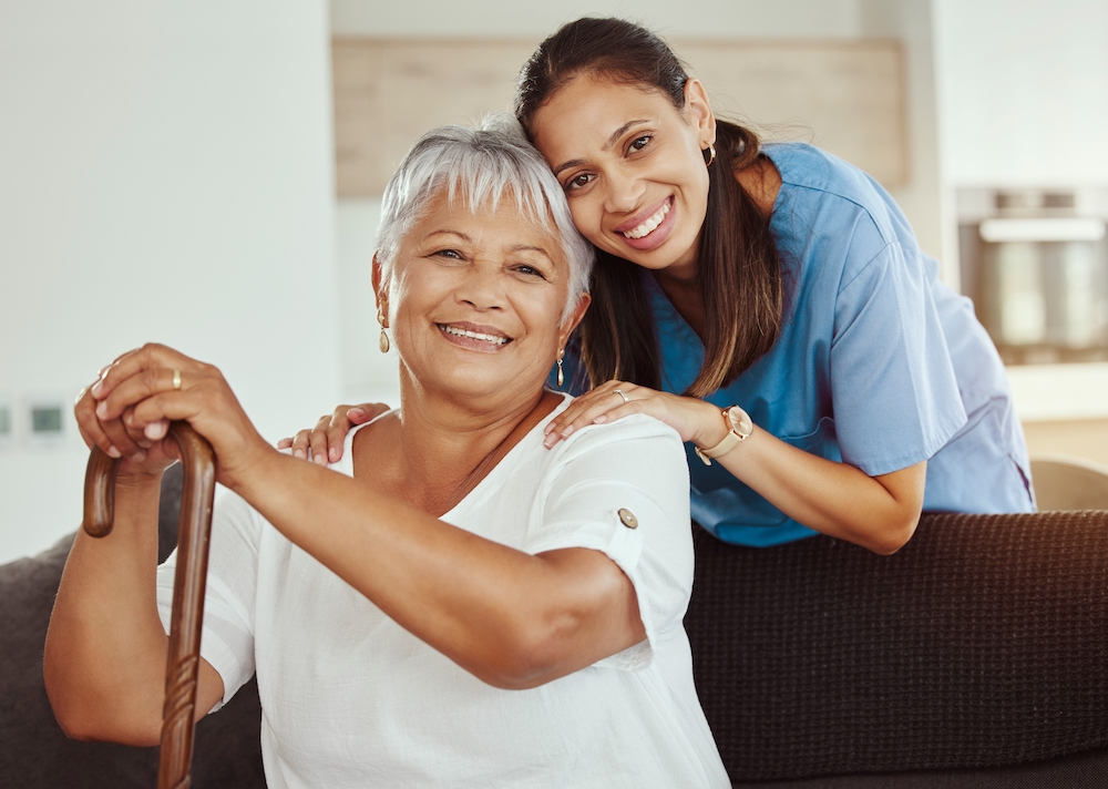 A senior woman sitting with a caregiver at the memory care community in Oceanside