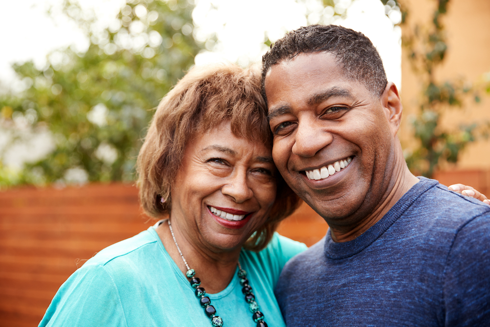 A senior woman and her adult son share a hug