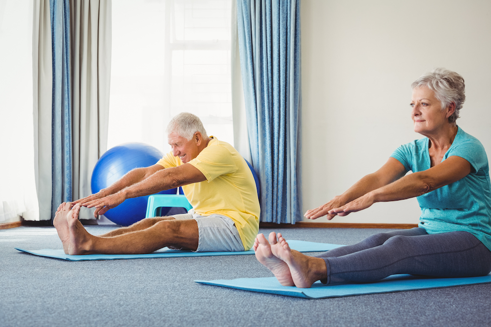A senior couple doing yoga and working out at the best memory care living in Oceanside